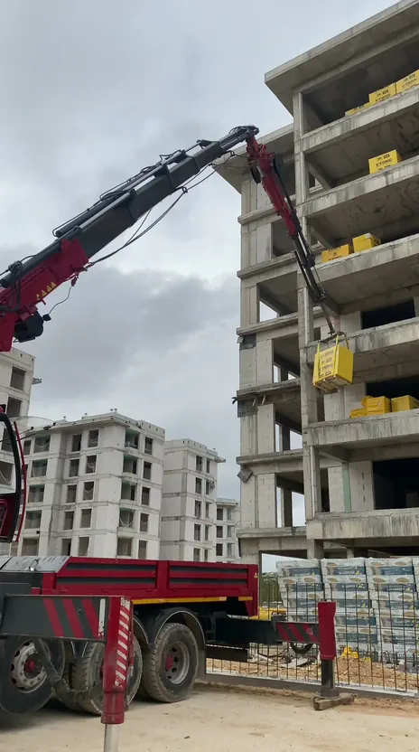 Hiyap vinçle tuğla paletlerinin inşaatın üst katlarına taşınması